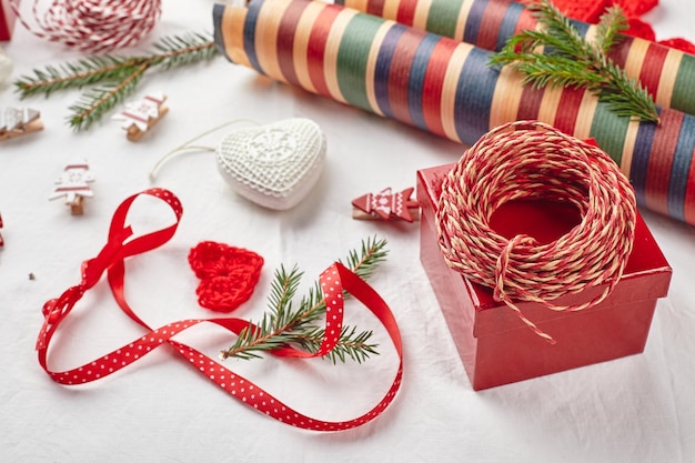 Fundo de Natal com rolos de papel de fio de fita de caixas de presente corações de malha e enfeite de Natal