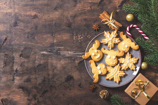 Fundo de natal. composição de natal com ramos de pinheiro, presentes, doces, biscoitos, canela em um fundo escuro de madeira