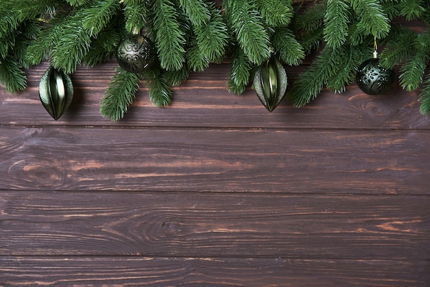 Fundo de Natal de Ano Novo com ramos de abeto e enfeites verdes em um pano de fundo de madeira