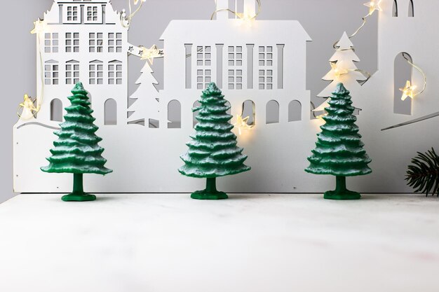 Fundo de Natal de Ano Novo Três árvores de abeto cobertas de neve no fundo de uma cidade de madeira