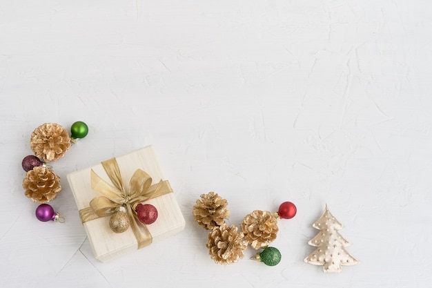 Foto fundo de natal. decoração de natal e caixa de presente ou presente decorada com fita dourada sobre fundo branco. vista superior, copie o espaço.