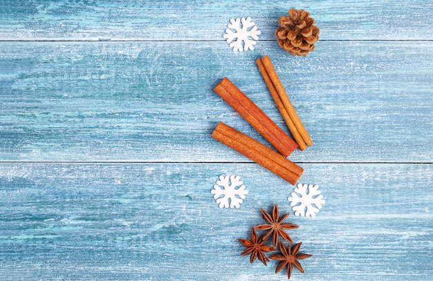 Foto fundo de natal: estrelas de anis, paus de canela, raminho de abeto, sobre um fundo azul de madeira