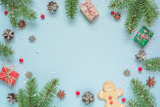 Fundo de Natal feito de galhos de árvores de abeto, decorações, frutas, pão de gengibre em fundo azul