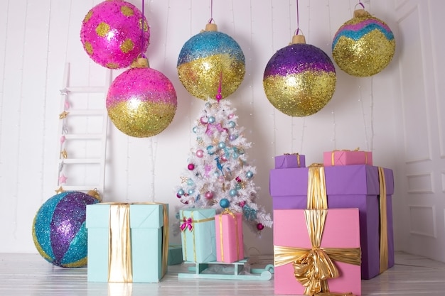Fundo de natal festivo uma árvore de natal artificial branca com brinquedos grandes bolas e trenó