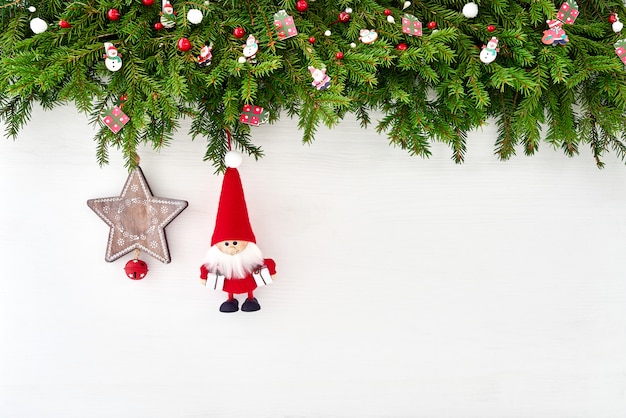 Fundo de Natal. Galho de árvore de abeto de Natal com Papai Noel em fundo branco de madeira. Policial