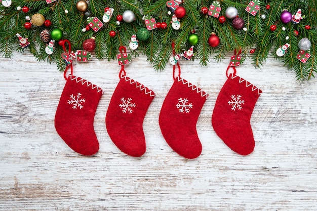 Fundo de natal. Meias de Natal vermelhas sobre fundo branco de madeira com pinheiro de Natal.