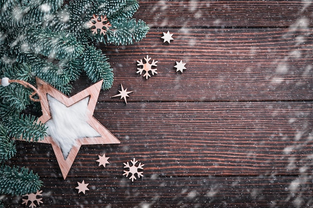 Fundo de Natal ou Ano Novo com ramos de abeto e flocos de neve de madeira e estrelas Caixa de presente de bolas de Natal em fundo escuro de madeira Lugar para o seu texto Cartão de saudação de Natal