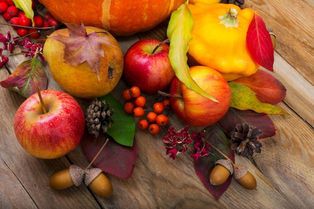Fundo de outono com abóbora amarela, maçãs, pêra, folhas coloridas