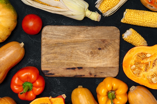 Fundo de outono com legumes frescos e tábua de madeira