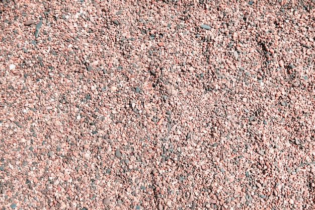Fundo de pequenos seixos de pedras cinza rosa e cinza na praia