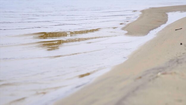 Foto fundo de praia com imagens de ondas marinhas água calma na praia de areia