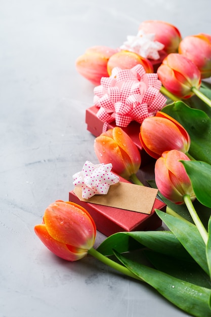 Fundo de primavera com tulipas coloridas laranja e caixa de presente, mulheres, dia das mães, cartão de felicitações, imagem do espaço de cópia