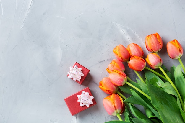 Fundo de primavera com tulipas coloridas laranja e caixa de presente, mulheres, dia das mães, cartão de felicitações, imagem plana e cópia do espaço