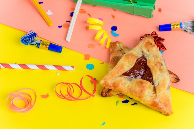 Foto fundo de purim com fantasia de festa e biscoitos hamantaschen