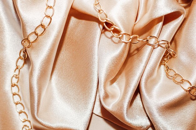 Fundo de seda texturizado dourado brilhante em dobras com miçangas.