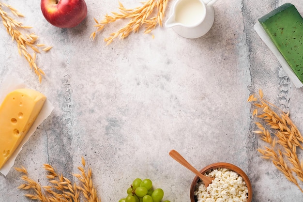 Fundo de Shavuot feliz para celebração de Shavuot Leite e queijo trigo maduro e frutas fundo de madeira azul Produtos lácteos sobre fundo de concreto de mesa cinza velha Conceito de Shavuot Mock up