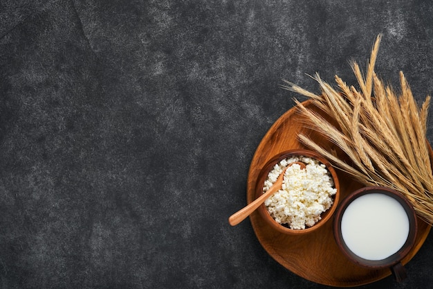 Fundo de Shavuot feliz para celebração judaica religiosa tradicional de Shavuot Leite e queijo trigo maduro e frutas Produtos lácteos sobre fundo cinza escuro antigo Conceito de Shavuot Vista superior Mock up