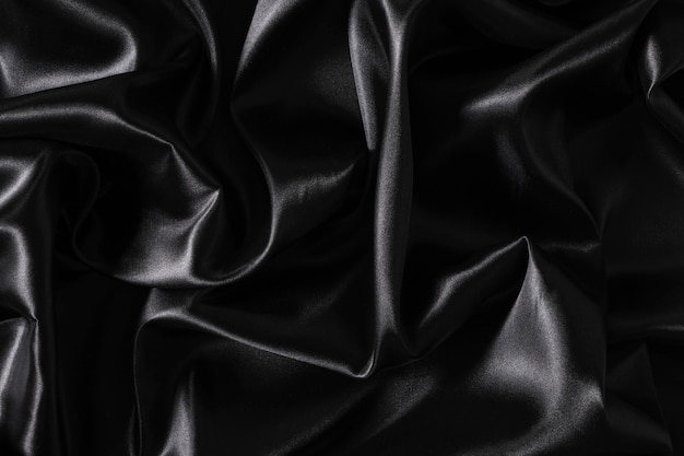 Foto fundo de tecido de cetim preto ondulado abstrato de tecido de seda