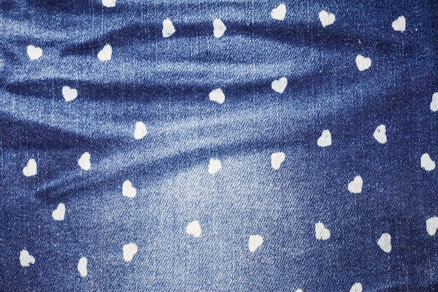 Fundo de textura de jeans azul pequeno coração.