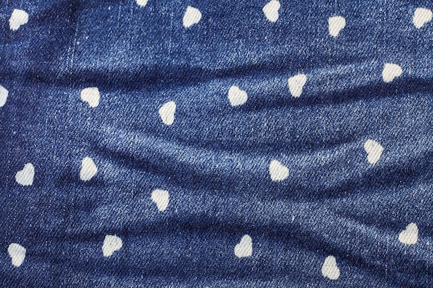 Fundo de textura de jeans azul pequeno coração.