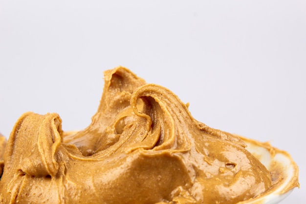 Fundo de textura de manteiga de amendoim Redemoinho de noz marrom suave e cremoso close-up Deliciosa macro de macarrão de comida natural escura