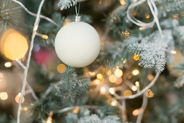 fundo de textura Galho de árvore de Natal com brinquedo. brinquedo branco com padrões. lâmpada festão