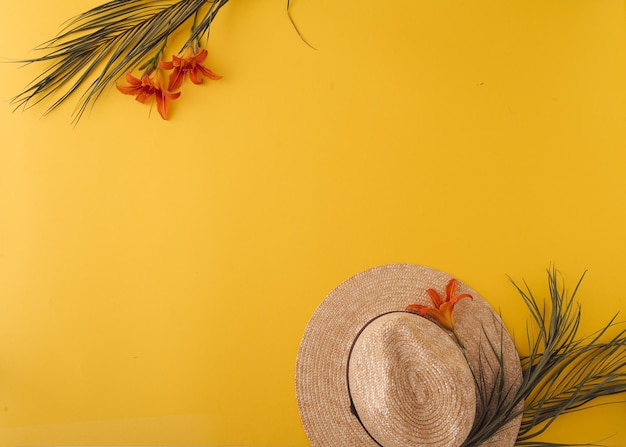 Fundo de verão com chapéu de palha e bolsa e folhas de palmeira