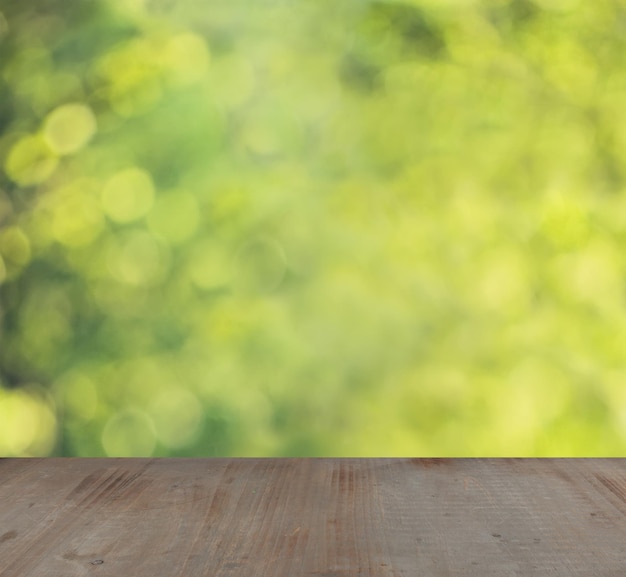 Fundo de verão de foco suave com bokeh verde e amarelo abstrato e placa de madeira vazia cinza com espaço de cópia