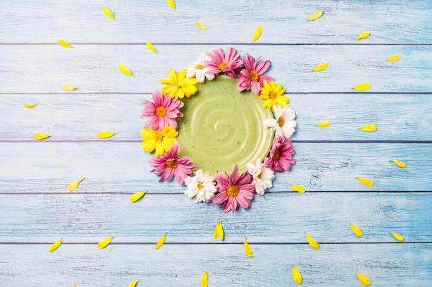 Fundo de verão: placa verde rodeada por flores gerbera sobre um fundo azul