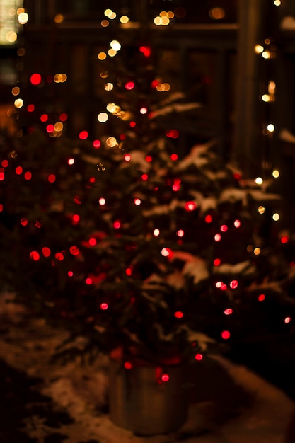 Fundo desfocado árvore festiva de natal decorada com luzes luminosas de guirlandas na rua