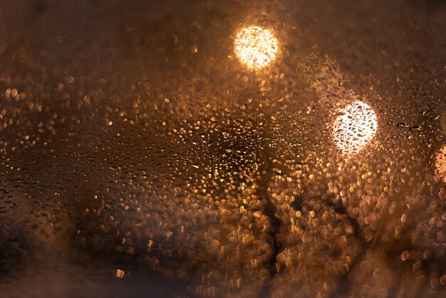 Fundo desfocado com gotas de chuva e luzes.