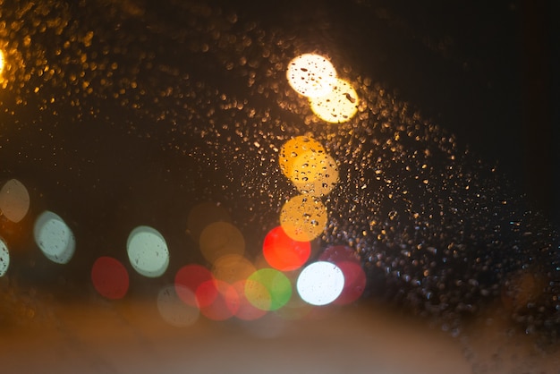 Fundo desfocado com gotas de chuva e luzes