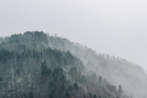 Fundo desfocado de forte queda de neve sobre as montanhas Clima de inverno tempestuoso