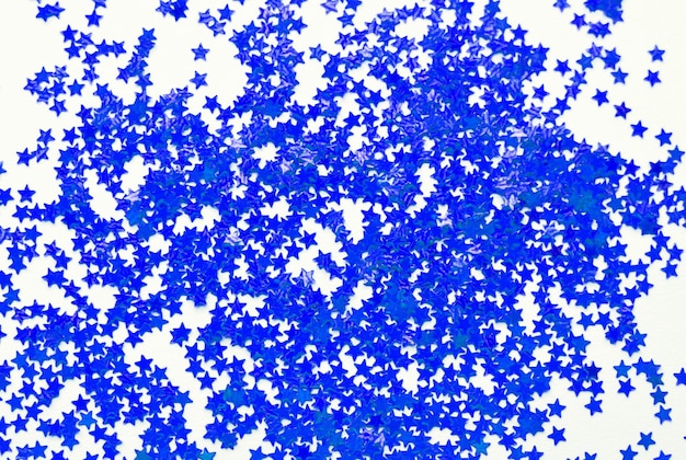 Fundo desfocado de pequenas estrelas azuis em um fundo branco. foco seletivo. conceito de natal.