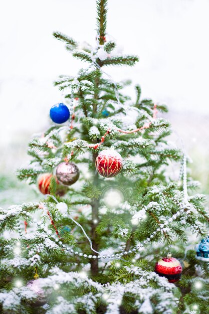 Fundo desfocado e desfocado da árvore de Natal com decorações do feriado, neve e bokeh.