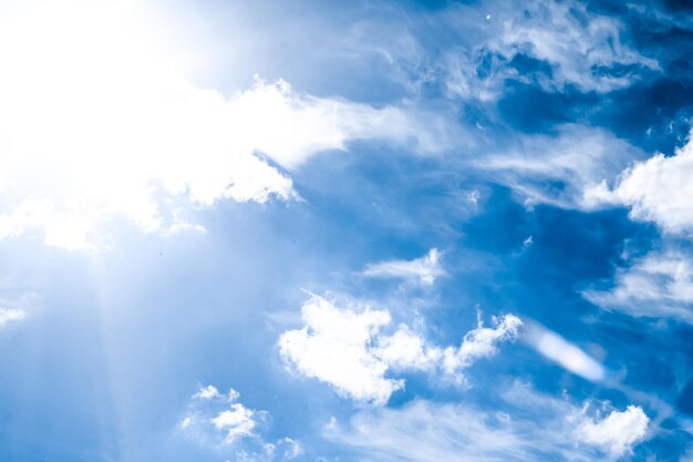 Fundo do céu azul com nuvens brancas e luz solar intensa