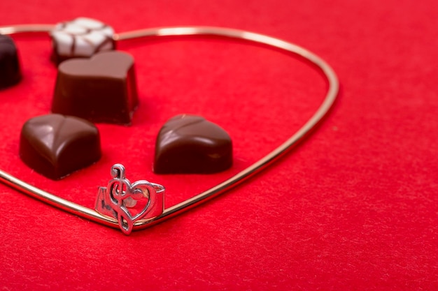 Fundo do dia dos namorados Chocolates em forma de coração com um anel de amor em feltro vermelho e uma coroa de coração de ouro