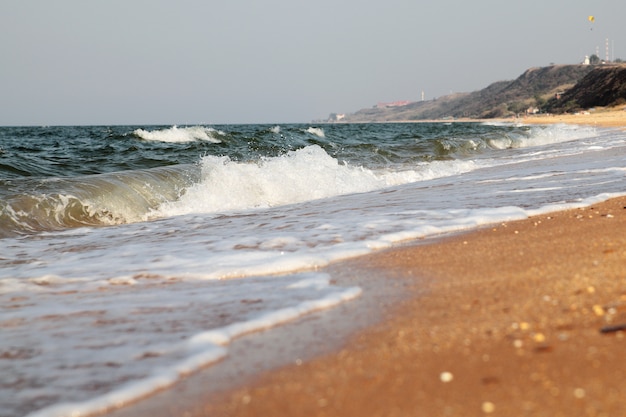 Foto fundo do mar tempestuoso. ondas e salpicos. praia de areia.