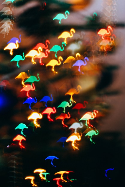 Fundo do Natal, bokeh sob a forma de um flamingo cor-de-rosa. Desfoque de fundo