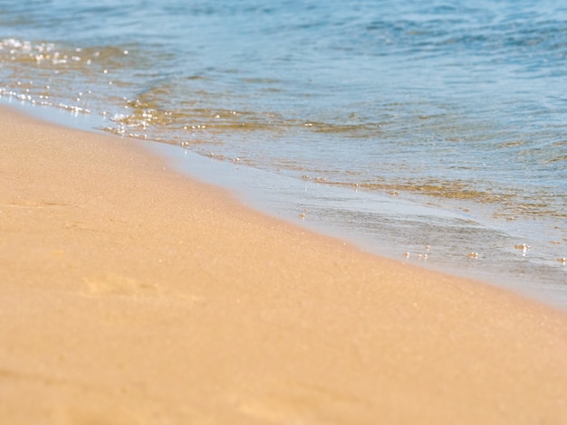 Fundo do verão da água do mar da areia da praia.