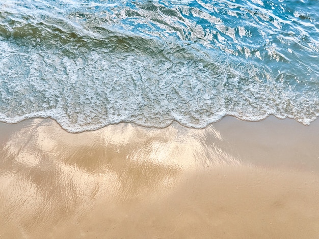 Fundo do verão da água do mar da areia da praia.