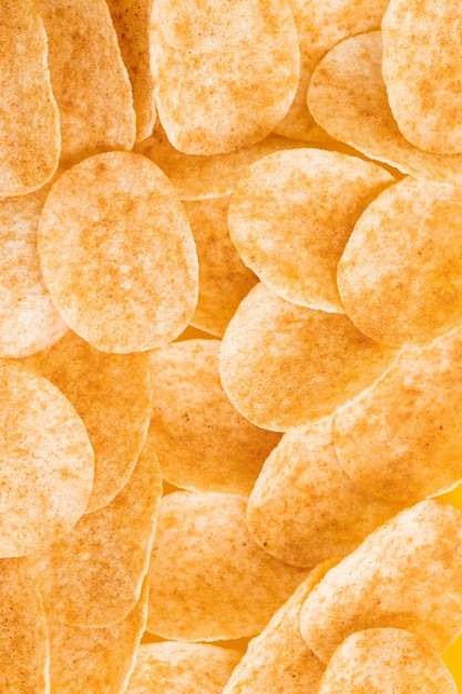 Fundo e textura de um monte de batatas fritas giratórias sobre fundo amarelo Vista de cima