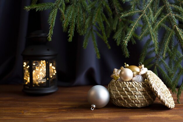 Fundo escuro de Natal, uma cesta com brinquedos de Natal em uma mesa de madeira