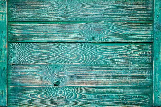 Foto fundo horizontal de tábuas de madeira pintadas com tinta verde e prendidas com uma prancha fina nas laterais.