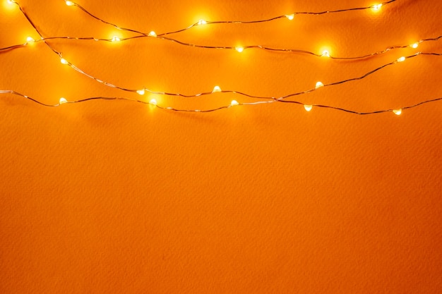Fundo laranja com luzes iluminadas de guirlanda
