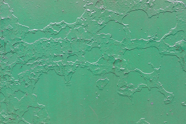 Fundo metálico verde com casca e pintura rachada.