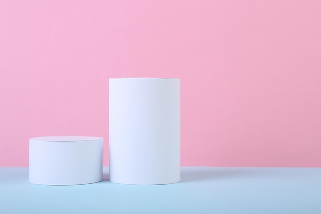 Fundo minimalista de formas geométricas dois cilindros em um fundo azul pastel rosa