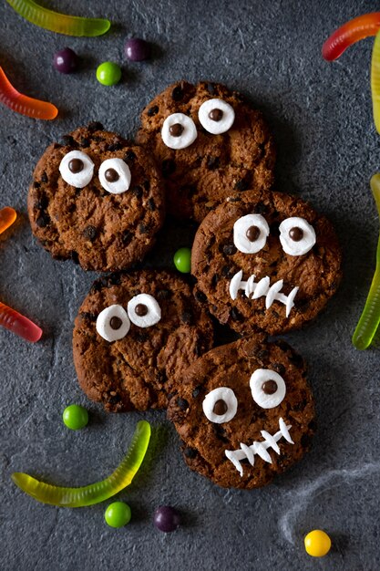 Fundo moderno de Halloween. Cookies de Halloween. Monstros engraçados feitos de biscoitos com chocolate na mesa