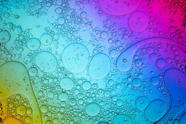 Fundo multicolorido com várias gotas de água flutuando na superfície