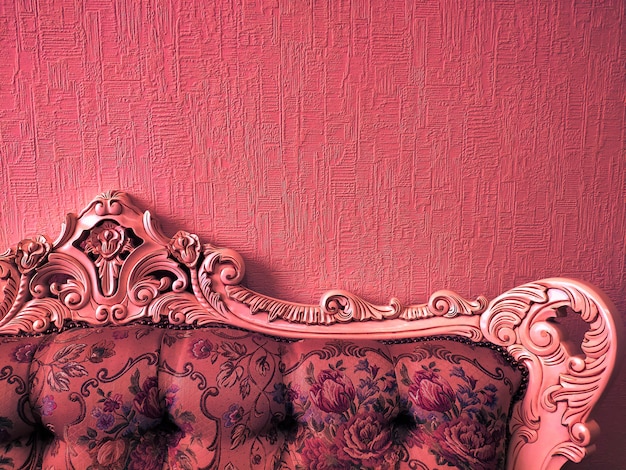 Fundo ou conceito, a parte de trás do sofá no estilo Império, luz de néon, coral.